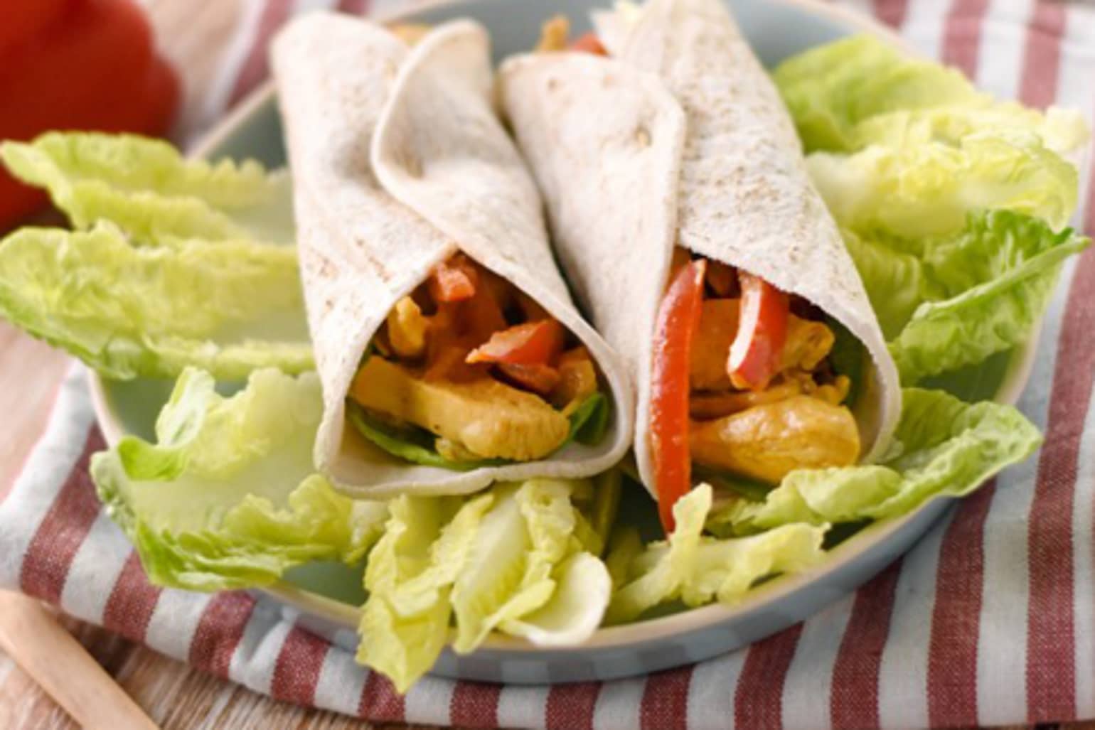 Old El Paso fajitas filled with chicken curry and vegetables sitting on a bed of lettuce